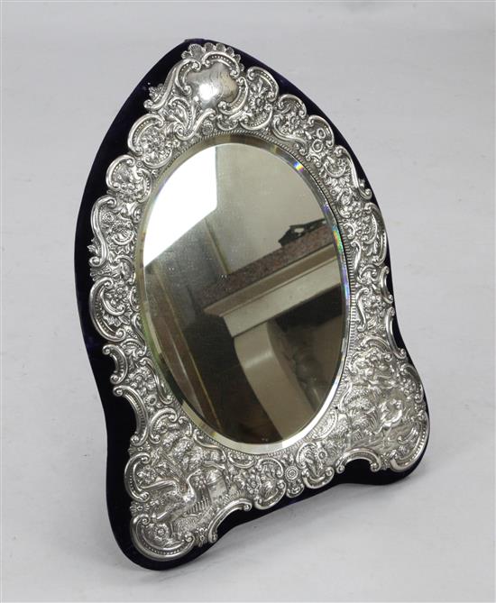 A late Victorian large repousse silver mounted oval dressing table easel mirror by Carrington & Co, 23.5 in overall.